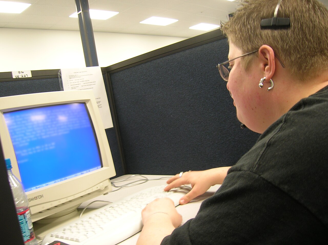 A call centre worker wearing a headset at a booth in Lakeland, Florida, working at a computer