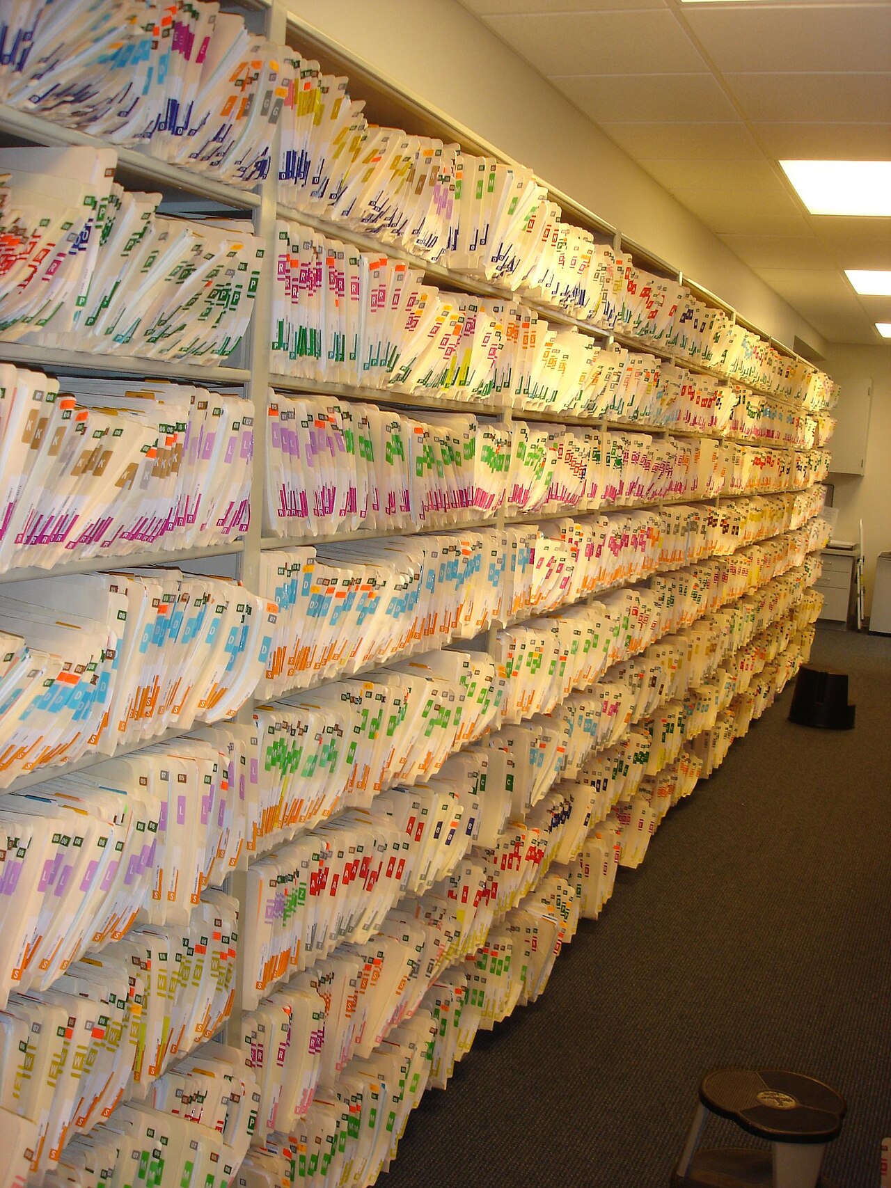 Shelves packed with labeled file folders in a records room